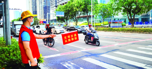     文明交通志愿者在路口引導文明出行。